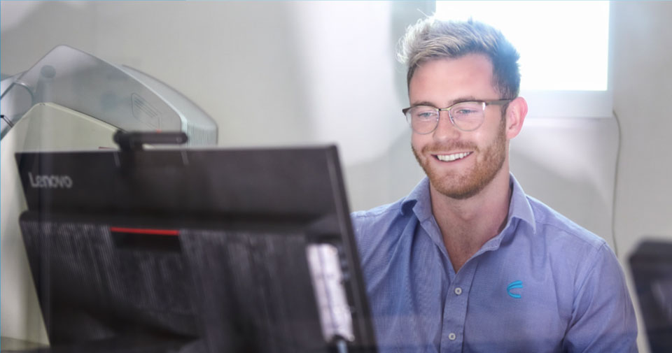 Man Smiling & Looking At A Computer Screen | Nearest Mammogram Clinic | Capital Radiology